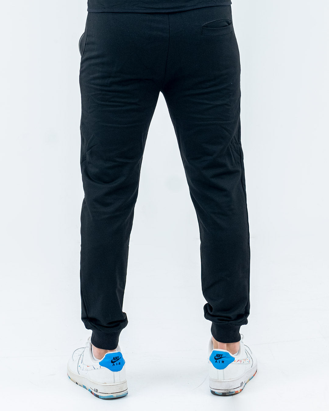 Aero pants mighty black on model, tapered fit cuffed hem